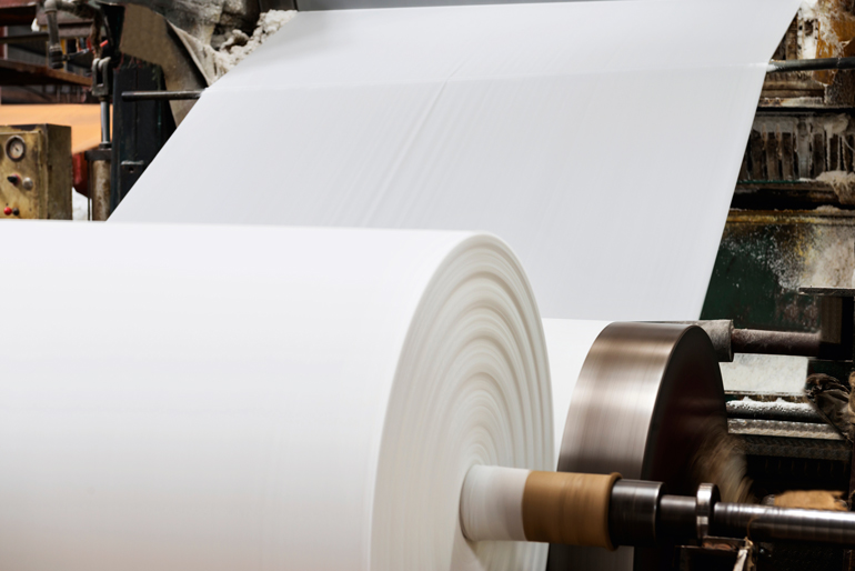 Eine große weiße Papierrolle auf einer Druckermaschine.