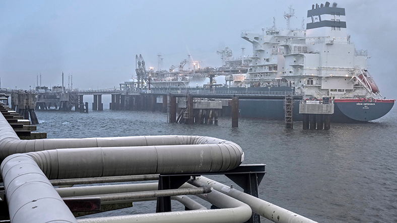 Gaspipeline in einem Hafen mit Schiff im Hintergrund.