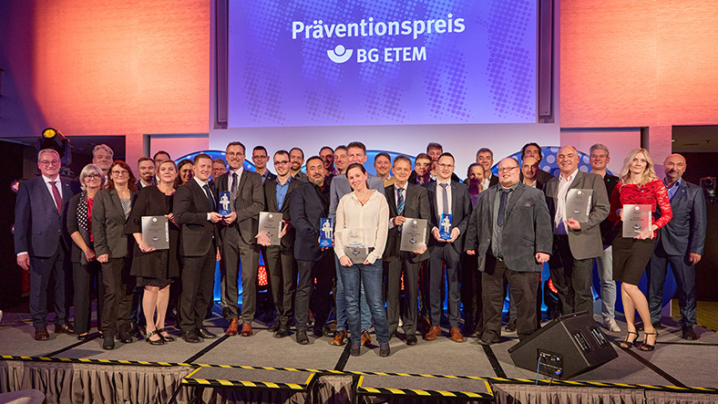Gewinn für den Arbeitsschutz: Die Preisträger des Präventionspreises 2022 stehen auf einer Bühne.