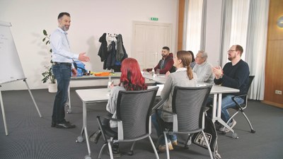 Ein Trainer informiert eine Seminargruppe zu einem Thema.