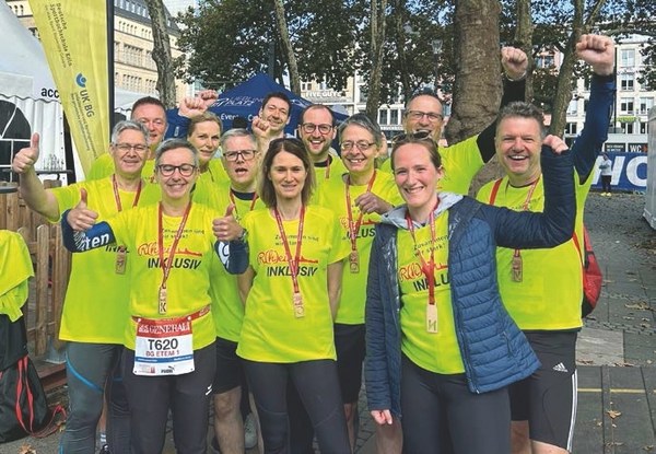 Das Laufteam der BG ETEM jubelt nach der Teilnahme beim Marathon.