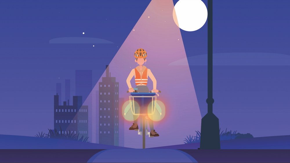 Ein Zeitungszusteller fährt auf dem Fahrrad in der Nacht stadtauswärts. Er durchfährt den Lampenschein und trägt Projektoren. Die Lichter am Fahrrad sind eingeschaltet.