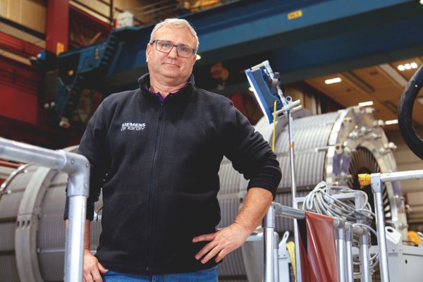 Ein Mitarbeiter von Siemens Energy vor einem  Montagerollringe zur Umsetzung einer horizontalen Montagelage.