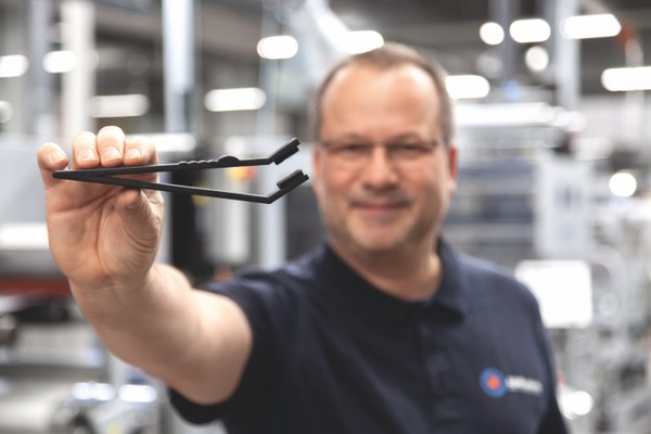 Ein Mitarbeiter hält ein Rakel in die Kamera.