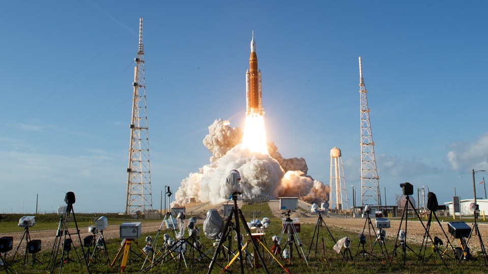 Raketenstart, der von zahlreichen Kameras im Vordergrund verfolgt wird